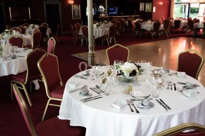 Salle de réception avec scène, piste de danse en bois, moquette rouge et plafond décoré d'une fresque.