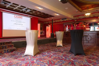 Salle de réception avec scène, piste de danse en bois, moquette rouge et plafond décoré d'une fresque.
