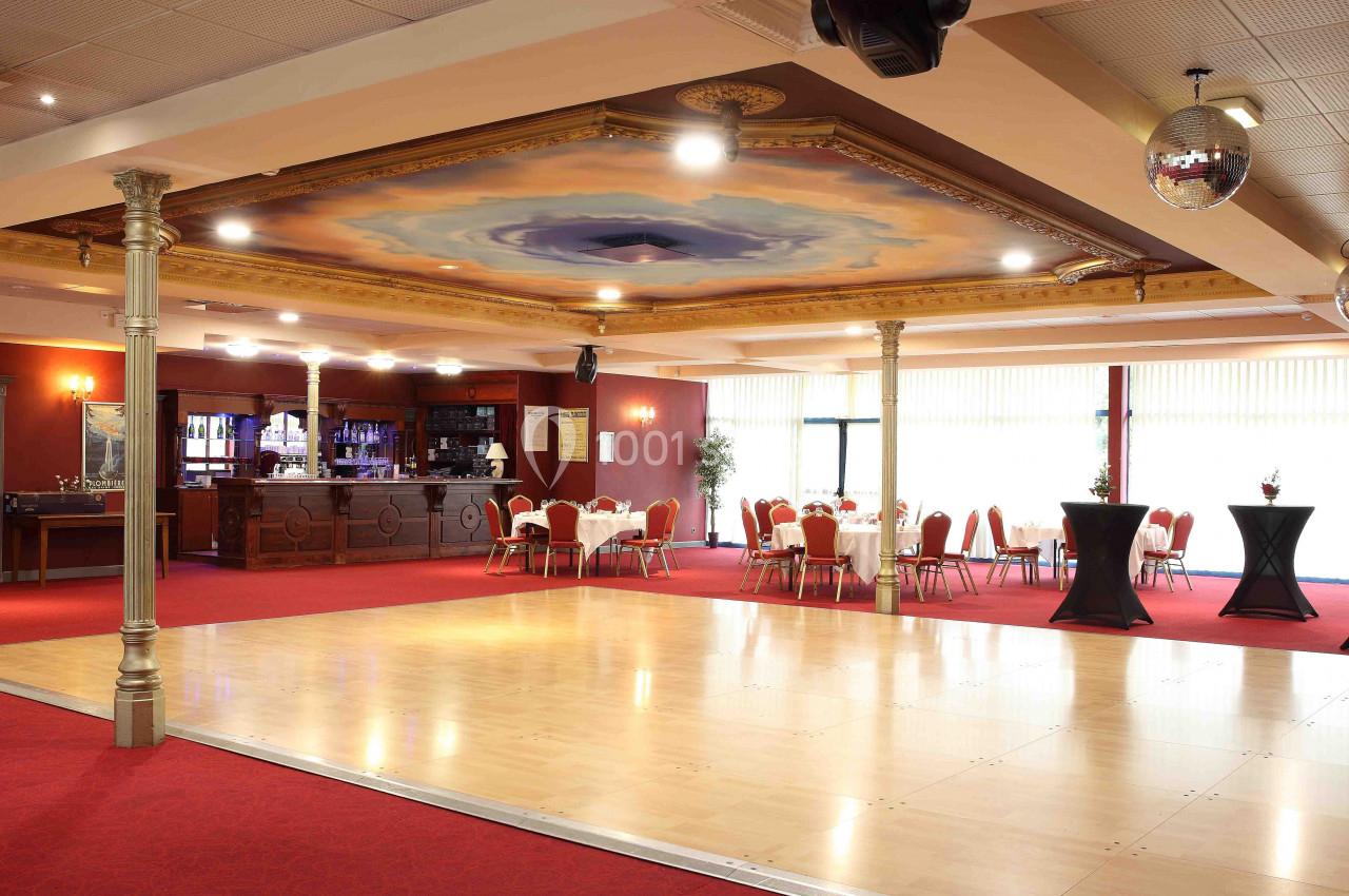 Piste et espace cocktail dinatoire Salle de réception avec parquet de danse, tables dressées, bar en arrière-plan et plafond décoré d'une fresque.