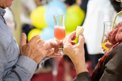 Un barman réalise un spectacle de flair bartending avec des verres et un shaker dans une salle éclairée.