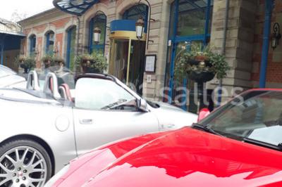 Un barman réalise un spectacle de flair bartending avec des verres et un shaker dans une salle éclairée.