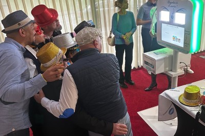 Miniature Animation : photobooth pour de bons moments et des souvenirs Bâtiment en briques rouges avec horloge, entouré de verdure, situé près d'un ruisseau et d'une pente herbeuse.