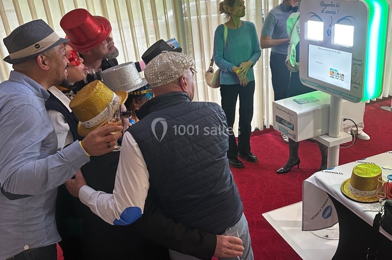 Animation : photobooth pour de bons moments et des souvenirs Des personnes portant des chapeaux festifs posent devant une borne photo interactive dans un espace intérieur.