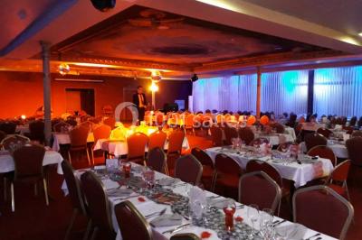Un barman réalise un spectacle de flair bartending avec des verres et un shaker dans une salle éclairée.