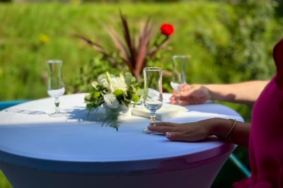 Miniature Charme et volupté sur la terrasse surplombant la rivière Bâtiment en briques rouges avec horloge, entouré de verdure, situé près d'un ruisseau et d'une pente herbeuse.