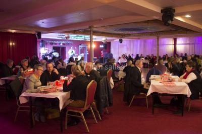 Un barman réalise un spectacle de flair bartending avec des verres et un shaker dans une salle éclairée.