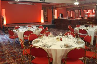 Un barman réalise un spectacle de flair bartending avec des verres et un shaker dans une salle éclairée.