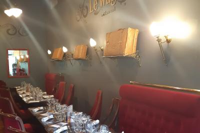 Un barman réalise un spectacle de flair bartending avec des verres et un shaker dans une salle éclairée.