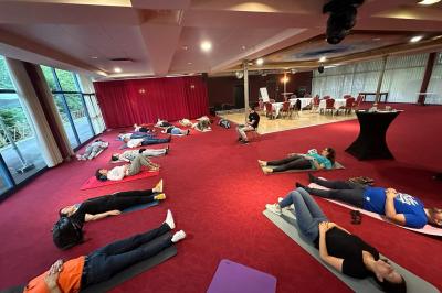 Un barman réalise un spectacle de flair bartending avec des verres et un shaker dans une salle éclairée.