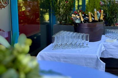 Miniature Prêt pour un moment privilégié sur la terrasse Bâtiment en briques rouges avec horloge, entouré de verdure, situé près d'un ruisseau et d'une pente herbeuse.