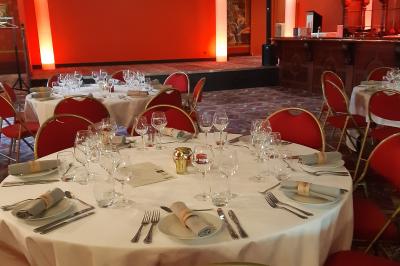 Un barman réalise un spectacle de flair bartending avec des verres et un shaker dans une salle éclairée.