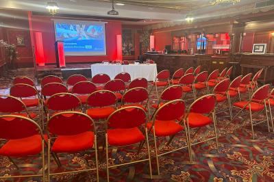 Un barman réalise un spectacle de flair bartending avec des verres et un shaker dans une salle éclairée.