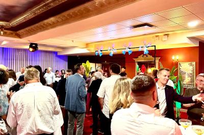 Un barman réalise un spectacle de flair bartending avec des verres et un shaker dans une salle éclairée.