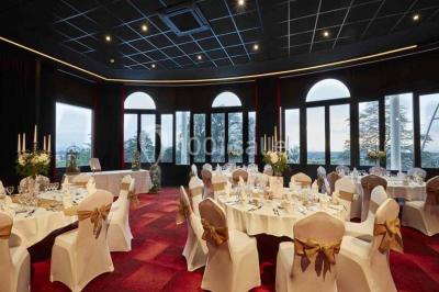 Façade d'un bâtiment avec l'inscription ’Casino’, terrasse animée, parasols blancs et piscine en contrebas.
