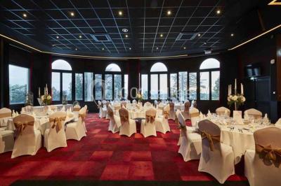 Façade d'un bâtiment avec l'inscription ’Casino’, terrasse animée, parasols blancs et piscine en contrebas.