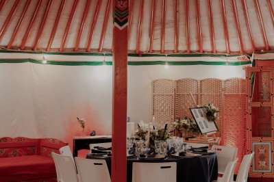 Assiette gastronomique avec une entrée raffinée composée de légumes, sauce jaune et décoration florale comestible.