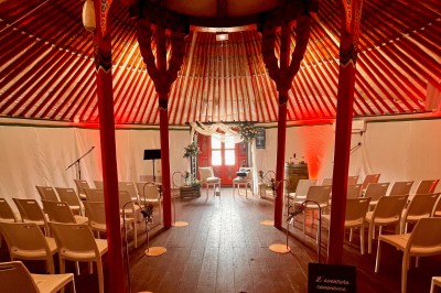 Assiette gastronomique avec une entrée raffinée composée de légumes, sauce jaune et décoration florale comestible.