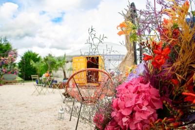 Assiette gastronomique avec une entrée raffinée composée de légumes, sauce jaune et décoration florale comestible.