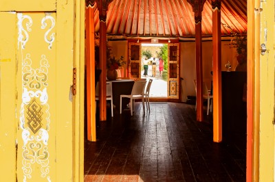 Assiette gastronomique avec une entrée raffinée composée de légumes, sauce jaune et décoration florale comestible.