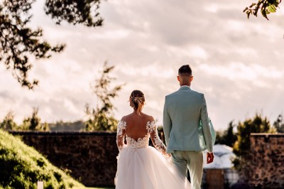 Assiette gastronomique avec une entrée raffinée composée de légumes, sauce jaune et décoration florale comestible.