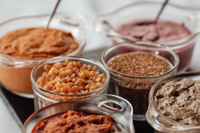 Assiette gastronomique avec une entrée raffinée composée de légumes, sauce jaune et décoration florale comestible.