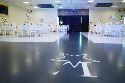 Façade d'une salle de réception avec une entrée accessible et un parking devant.