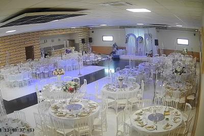 Façade d'une salle de réception avec une entrée accessible et un parking devant.