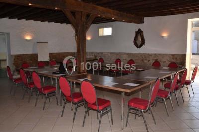 Lit double avec une couverture colorée, deux oreillers, tables de chevet en bois et une lampe dans une chambre simple.