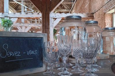 Des bancs en bois disposés en extérieur, entourés de décorations végétales, avec des arbres et des bâtiments en arrière-plan.