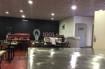 Dessert dressé sur une assiette blanche avec coulis de fruits rouges, tranche de kiwi, chantilly et éclats d'amandes.