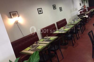 Dessert dressé sur une assiette blanche avec coulis de fruits rouges, tranche de kiwi, chantilly et éclats d'amandes.