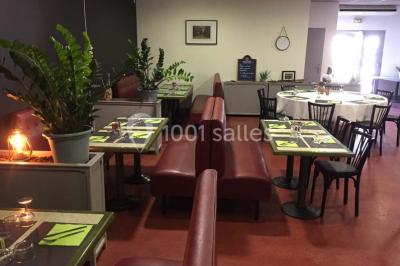 Dessert dressé sur une assiette blanche avec coulis de fruits rouges, tranche de kiwi, chantilly et éclats d'amandes.