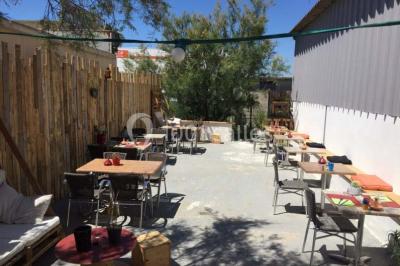Dessert dressé sur une assiette blanche avec coulis de fruits rouges, tranche de kiwi, chantilly et éclats d'amandes.