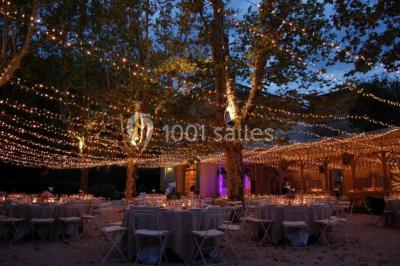 Salle de bain avec carrelage bleu et blanc à motifs, deux lavabos, un miroir et une fenêtre avec rideaux blancs.
