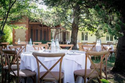 Salle de bain avec carrelage bleu et blanc à motifs, deux lavabos, un miroir et une fenêtre avec rideaux blancs.