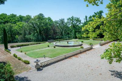 Salle de bain avec carrelage bleu et blanc à motifs, deux lavabos, un miroir et une fenêtre avec rideaux blancs.