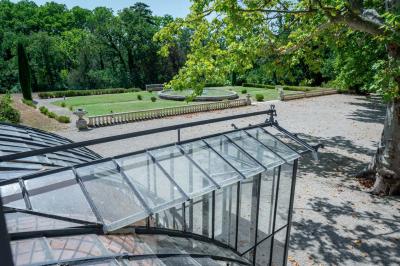 Salle de bain avec carrelage bleu et blanc à motifs, deux lavabos, un miroir et une fenêtre avec rideaux blancs.