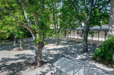 Salle de bain avec carrelage bleu et blanc à motifs, deux lavabos, un miroir et une fenêtre avec rideaux blancs.