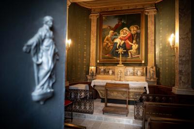 Salle de bain avec carrelage bleu et blanc à motifs, deux lavabos, un miroir et une fenêtre avec rideaux blancs.
