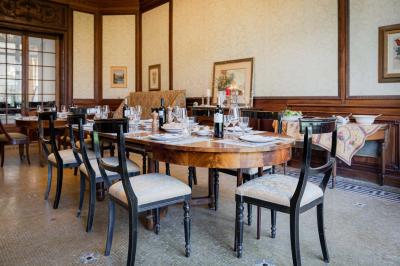 Salle de bain avec carrelage bleu et blanc à motifs, deux lavabos, un miroir et une fenêtre avec rideaux blancs.