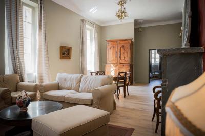 Salle de bain avec carrelage bleu et blanc à motifs, deux lavabos, un miroir et une fenêtre avec rideaux blancs.