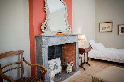 Salle de bain avec carrelage bleu et blanc à motifs, deux lavabos, un miroir et une fenêtre avec rideaux blancs.