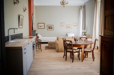Salle de bain avec carrelage bleu et blanc à motifs, deux lavabos, un miroir et une fenêtre avec rideaux blancs.