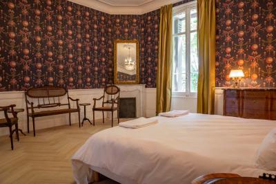 Salle de bain avec carrelage bleu et blanc à motifs, deux lavabos, un miroir et une fenêtre avec rideaux blancs.