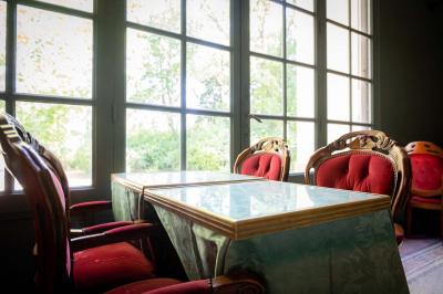 Salle de bain avec carrelage bleu et blanc à motifs, deux lavabos, un miroir et une fenêtre avec rideaux blancs.
