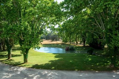 Salle de bain avec carrelage bleu et blanc à motifs, deux lavabos, un miroir et une fenêtre avec rideaux blancs.