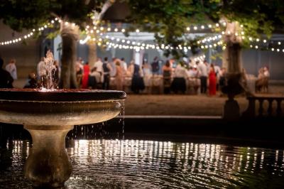 Salle de bain avec carrelage bleu et blanc à motifs, deux lavabos, un miroir et une fenêtre avec rideaux blancs.