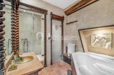 Deux statues humaines et un chien dans un parc verdoyant sous un ciel bleu avec des arbres en arrière-plan.