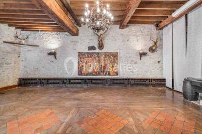 Deux statues humaines et un chien dans un parc verdoyant sous un ciel bleu avec des arbres en arrière-plan.