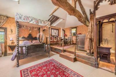 Deux statues humaines et un chien dans un parc verdoyant sous un ciel bleu avec des arbres en arrière-plan.